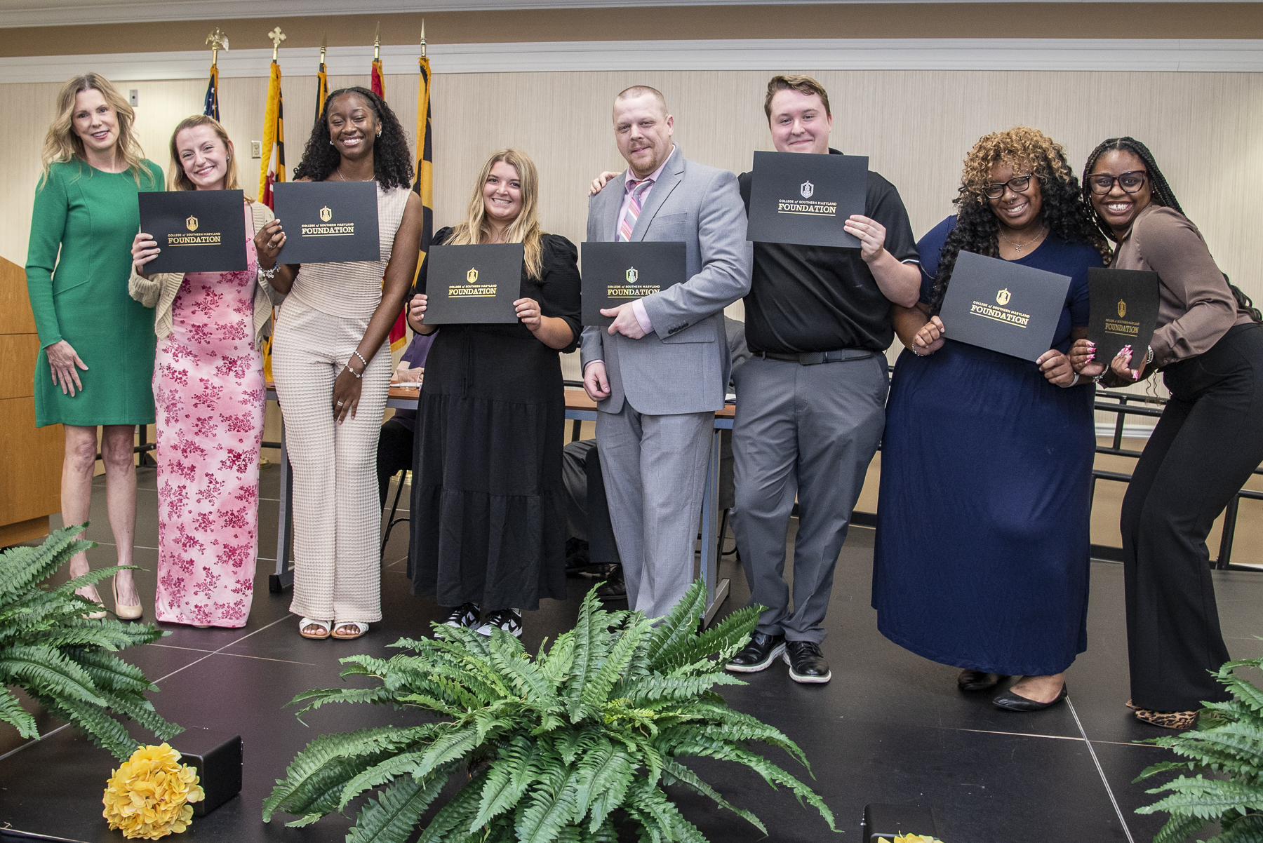 Academic Excellence Awards winners stand on stage with certificates