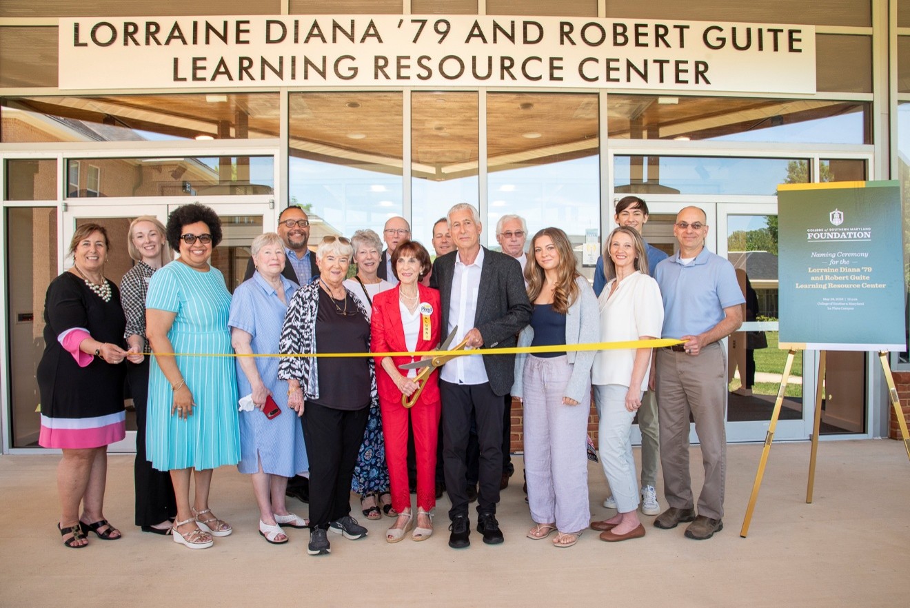 Lorraine Diana and Robert Guite stand with family, friends, and CSM leaders to cut the ribbon on their new building