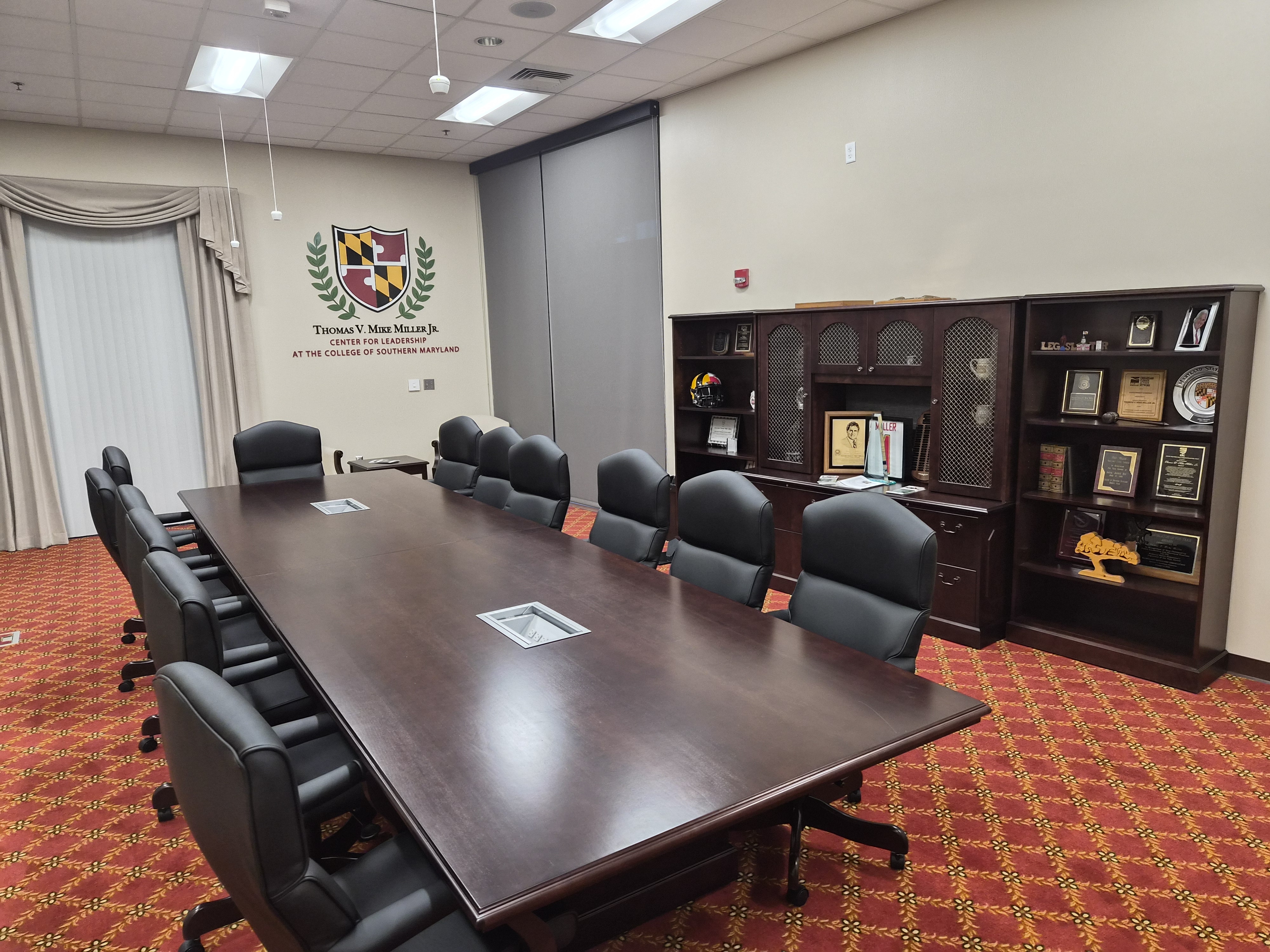 Conference table inside the Miller Center, bookshelf along one wall with Miller's memorabilia and certificates