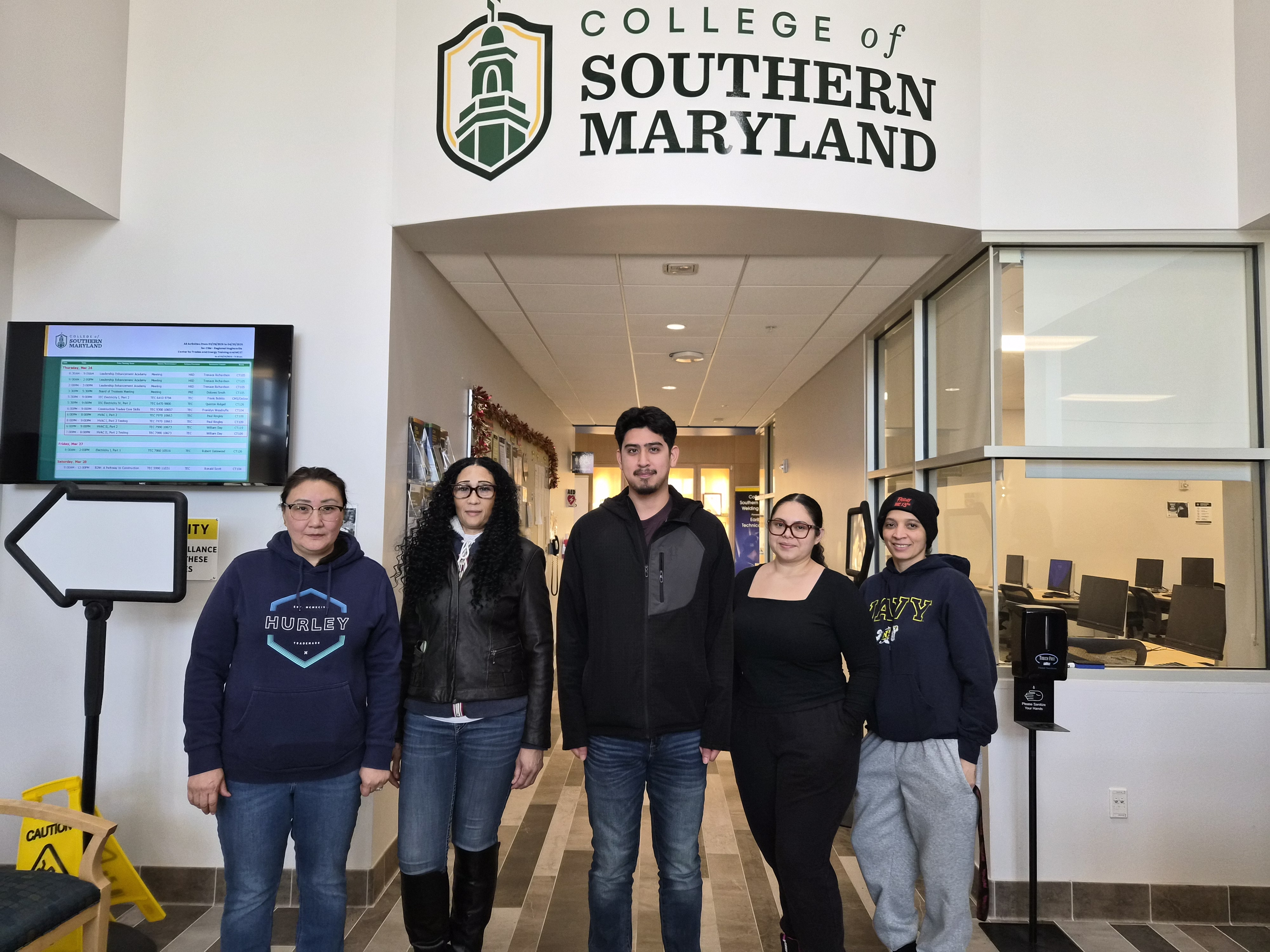 Students pose in front of CSM sign after completing certificates