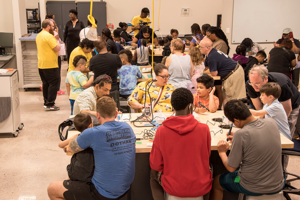 STEAM Fest attendees sit at tables working with 3D Printing Pens