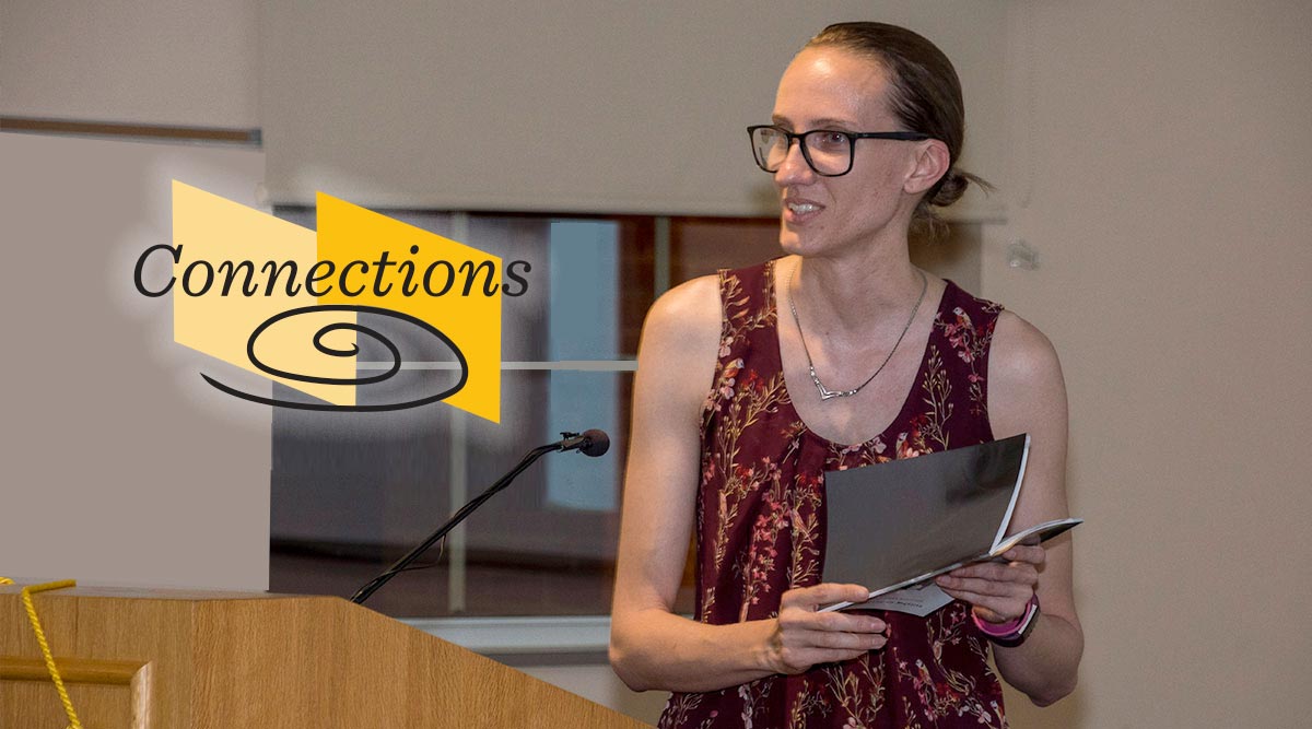 Author smiles while reading at a podium