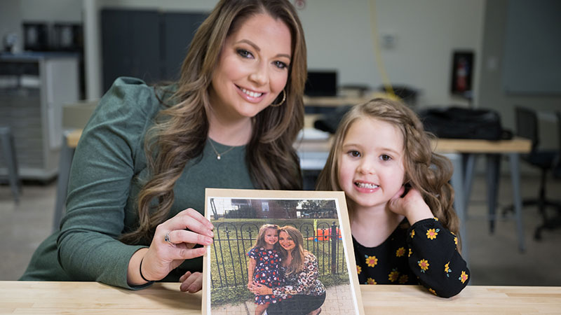 Woman and child smile with puzzle they created