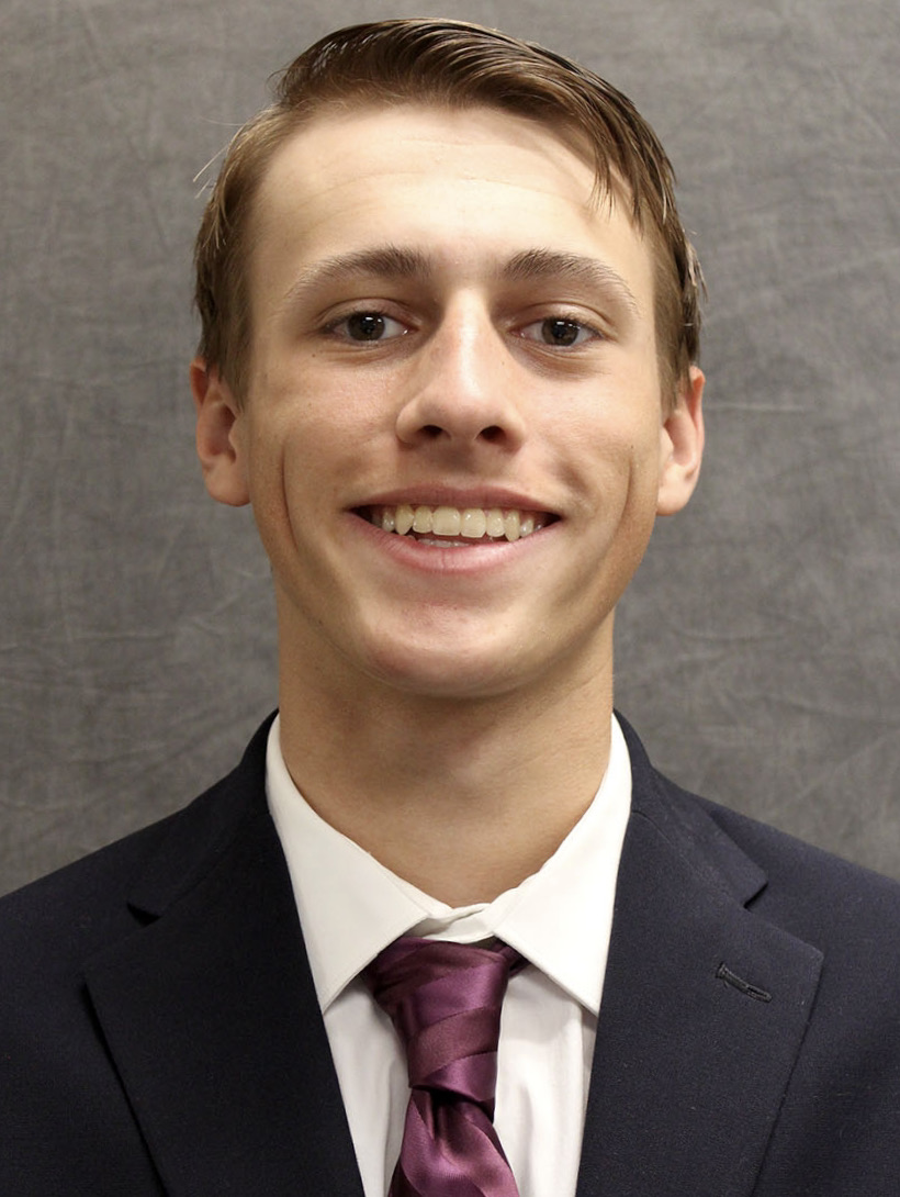 A headshot of CSM student Danny Mears, smiling at the camera and dressed in a suit and tie