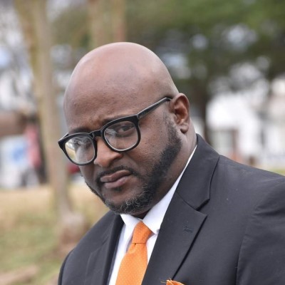 A photo of CSM student Dennis Allen dressed in a suit and tie