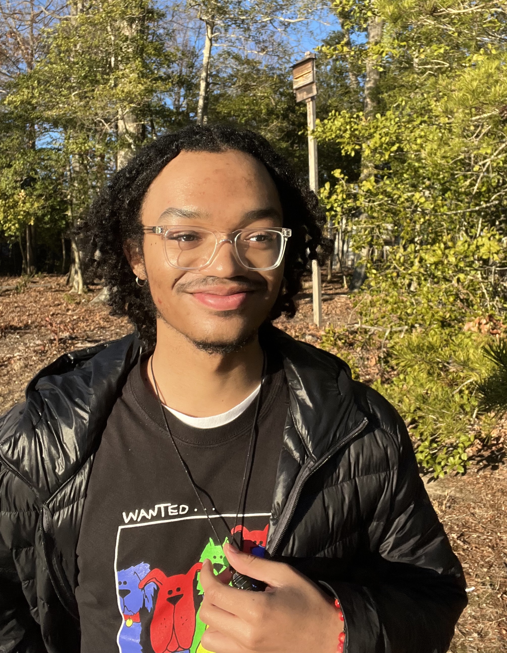 CSM student Jaryn Griggs, smiling, outdoors among trees