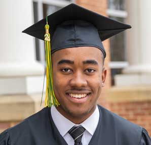 young man smiling in cap and gown