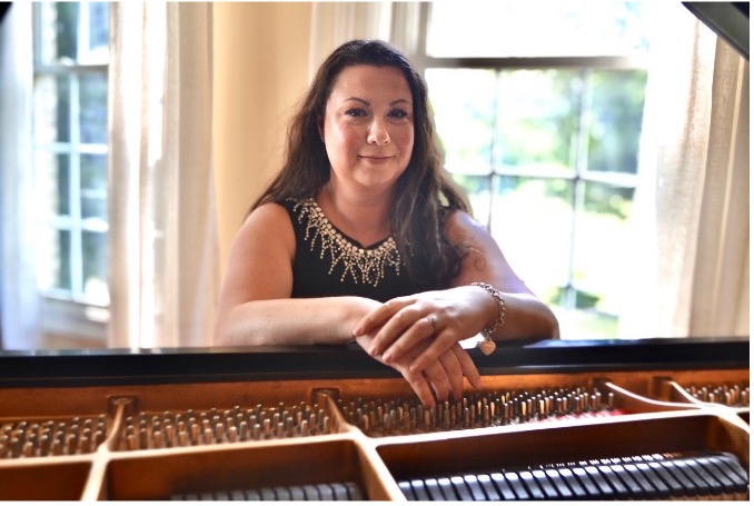 woman seated at piano smiles