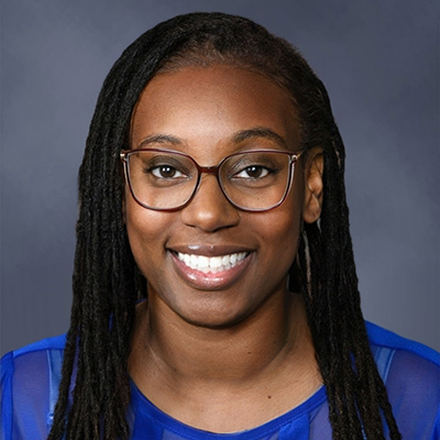 A professional headshot of CSM technology instructor Angel Stewart. She is wearing glasses with dark-red frames and a blue top and is smiling at the camera.