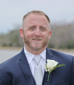 A photo of instructor Brian Reip, dressed in a suit