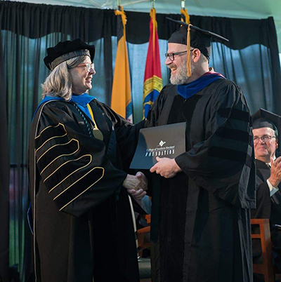 A photo of Dr. Richard Bilsker, on right, accepting an award from CSM President Dr. Maureen Murphy