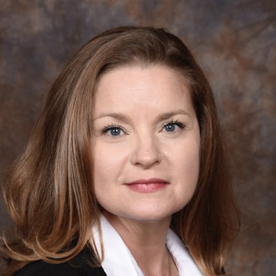 A professional headshot of CSM nursing clinical instructor Tasha Zochert, a woman with brown hair wearing a white shirt and black blazer