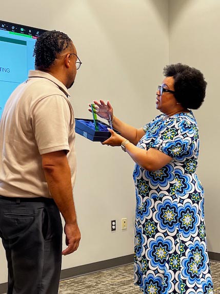 CSM President Dr. Yolanda Wilson presents Shawn Coates, Immediate Past Chair of the CSM Board of Trustees, with a plaque in appreciation of his years of service