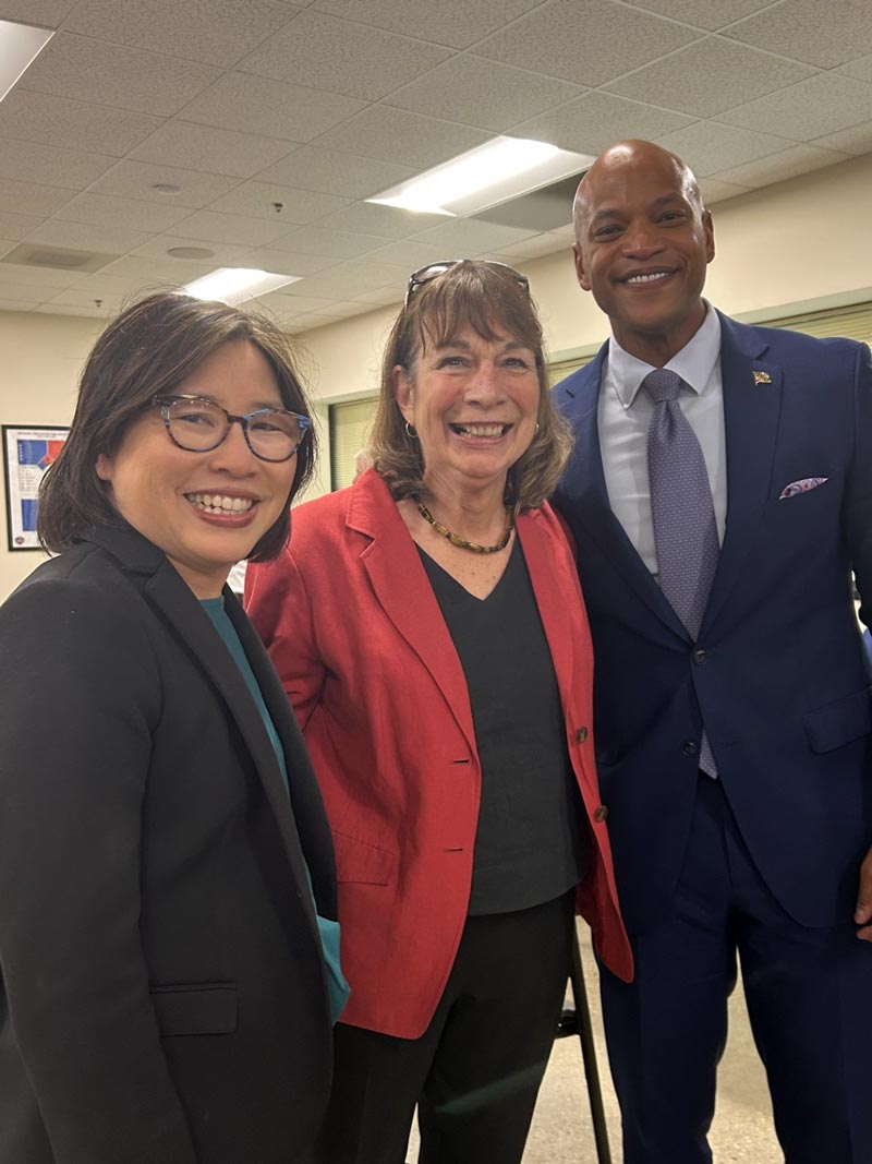 Three professionals posing together, smiling for the camera, in a well-lit indoor setting.