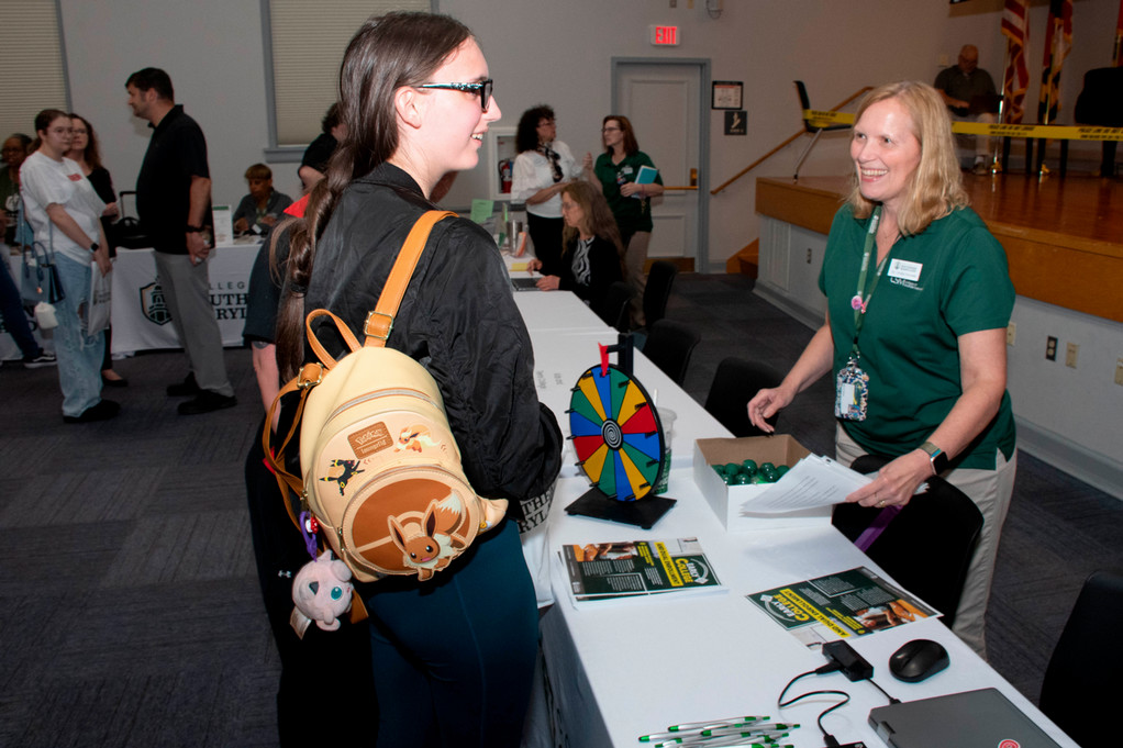 Prospective student stands at table during open house