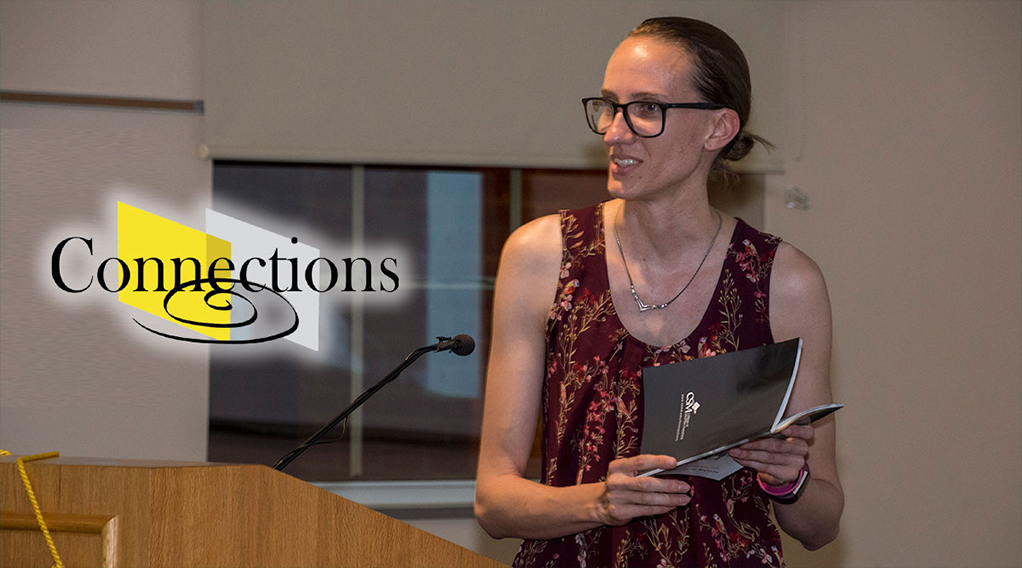Woman reads on stage at a podium