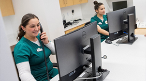 two women dressed in medical uniforms on computers