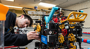 Student working on machine with rotary parts