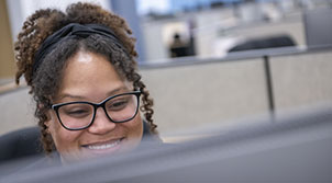 woman student smiling in front of her computer