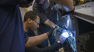 Students working on HVAC system in simulated lab.