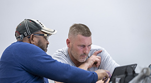 two men looking at a laptop