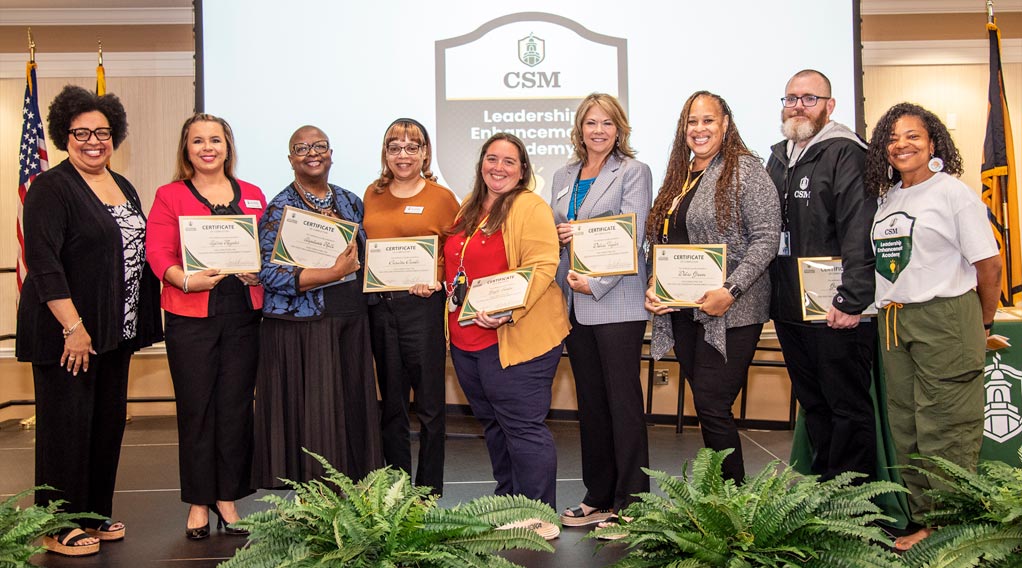 Group photo of participants receiving certificates at the Leadership Enhancement Academy event.
