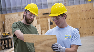 two men looking at blueprints at a construction site