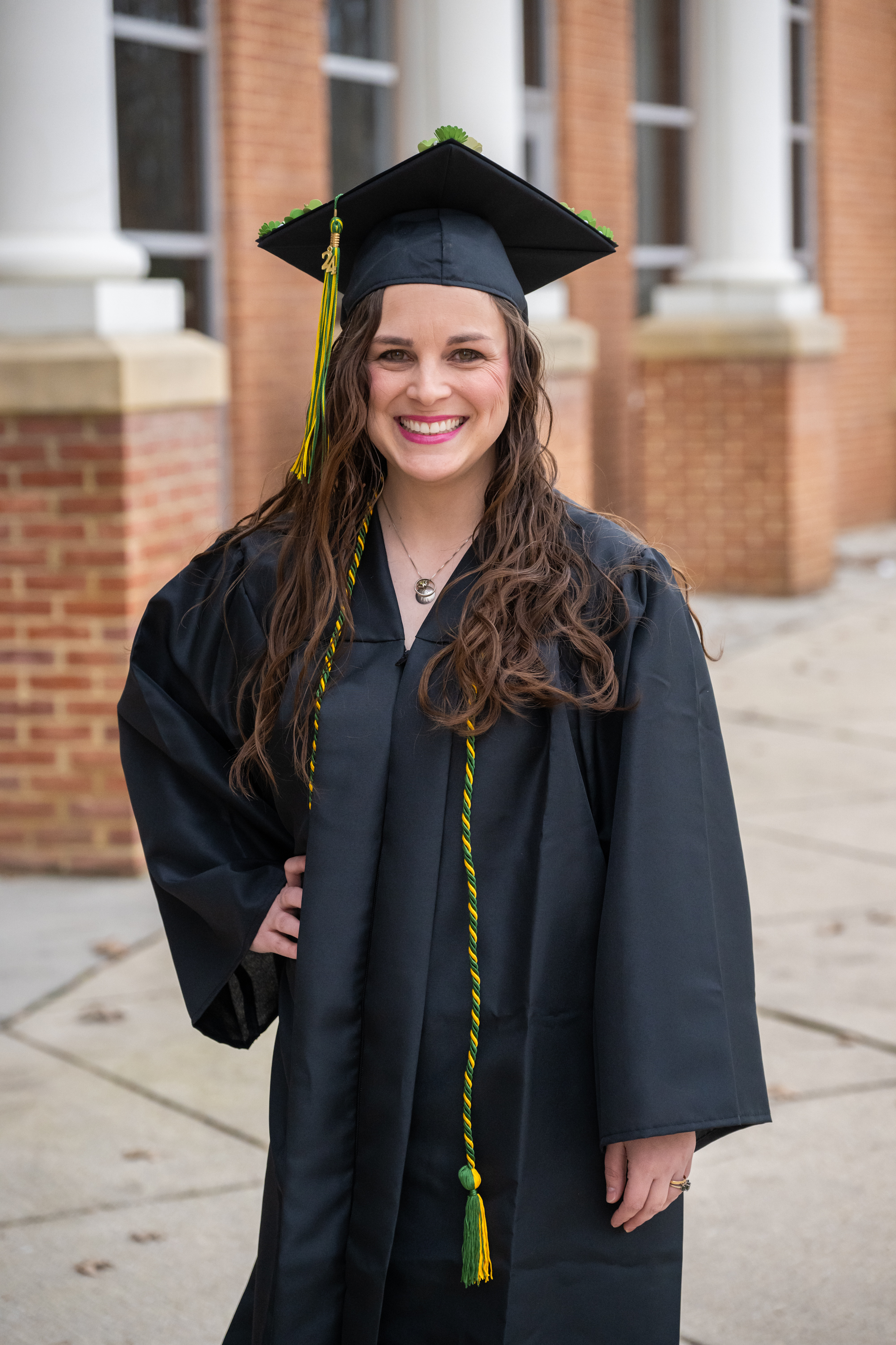 woman smiles in cap and gown