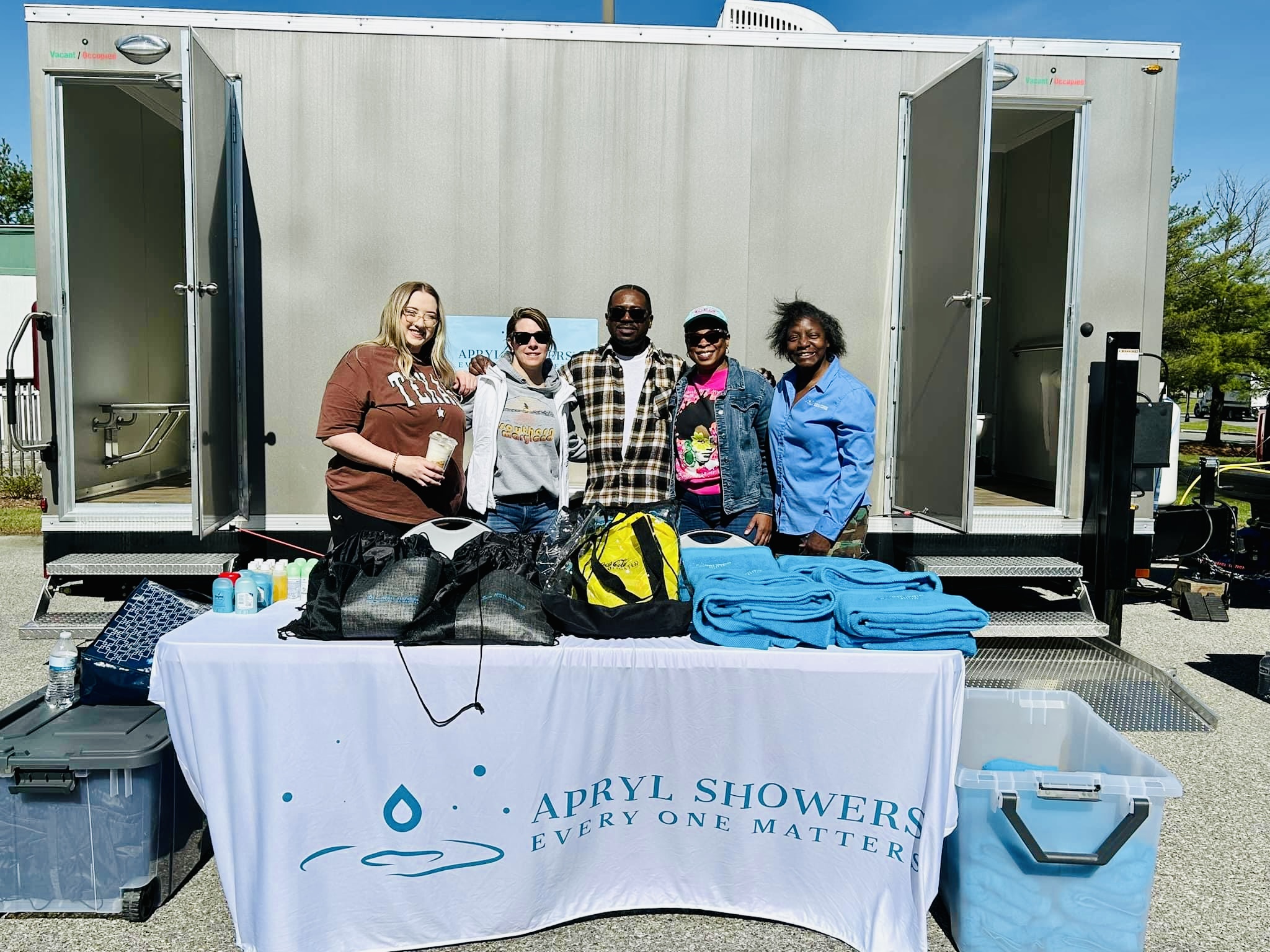 People standing in front of portable showers.