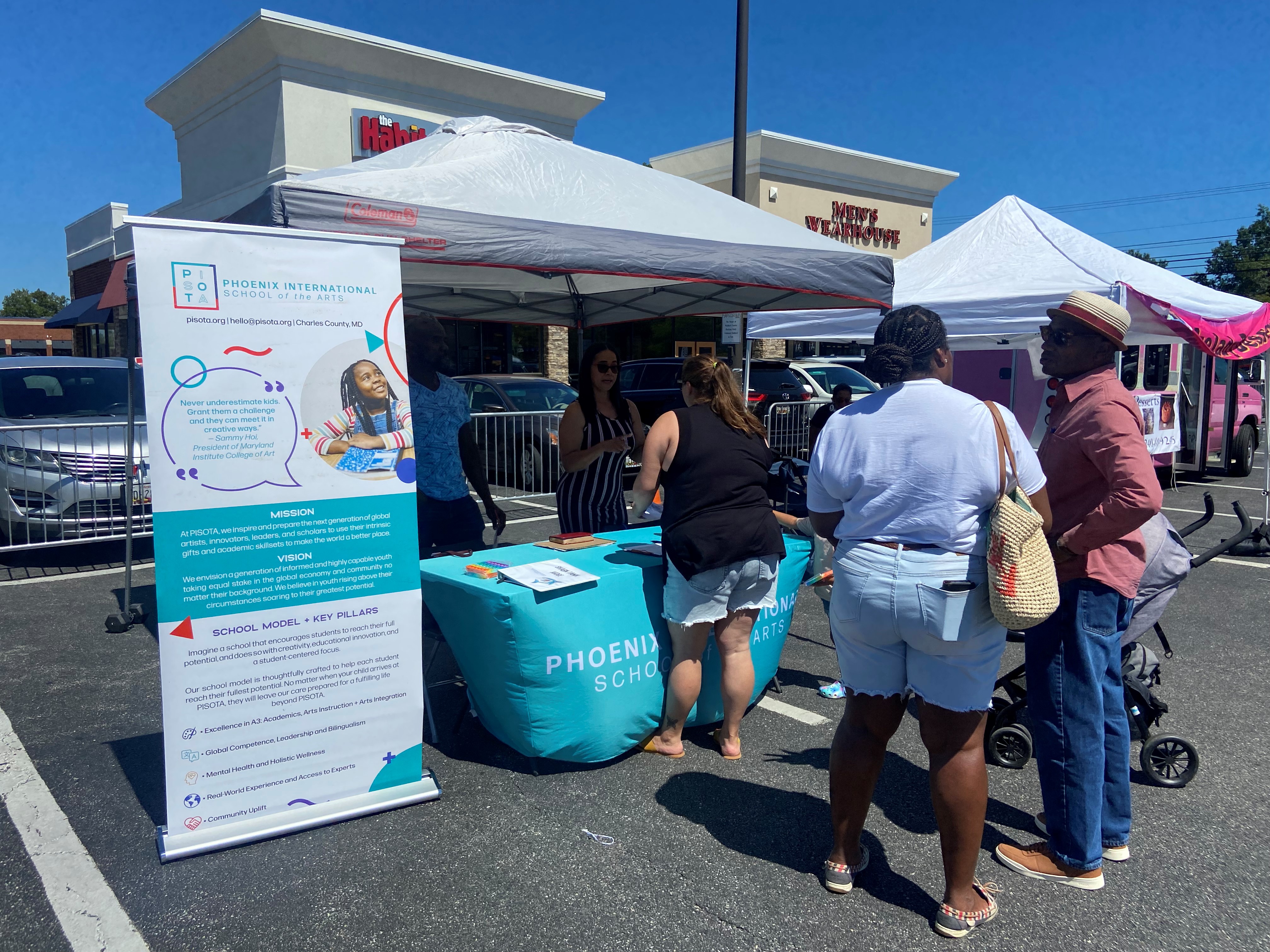 Staff speaks with prospective students at an outdoor booth